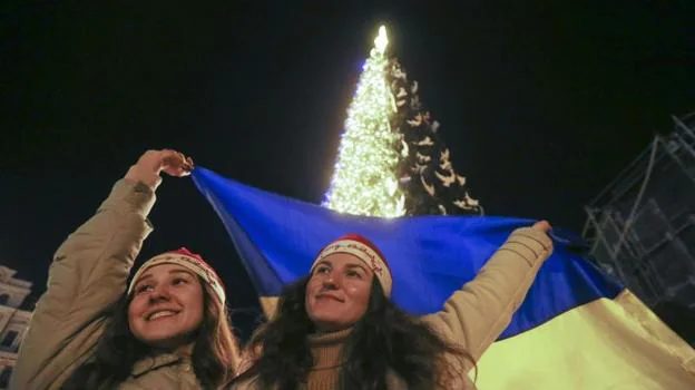 Dos jóvenes dan la bienvenida al nuevo año con la bandera de su país