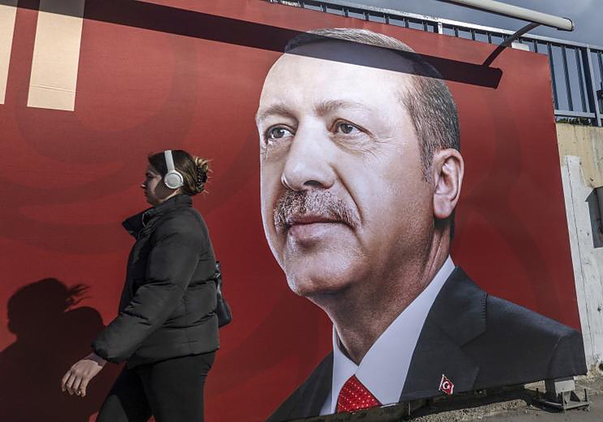 Una mujer pasa junto a un cartel de Erdogan en Estambul