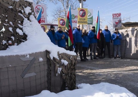 Imagen secundaria 1 - Arriba, imagen de las columnas de vehículos Rusos que discurren por la ruta entre Armenia y Karabaj. Debajo, a la izquierda, la protesta ecologista azerbaiyana que exige acceder a unos yacimientos cercanos y a la derecha, cartel en el territorio de Fizuli, al este de Karabaj, que alerta de la existencia de minas antipersona