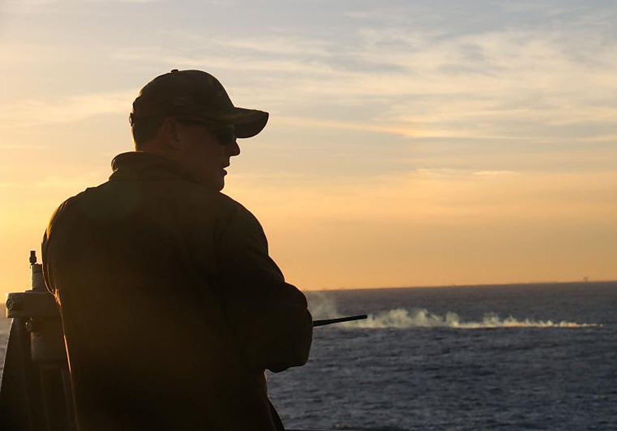 Un oficial al mando del barco de aterrizaje del muelle USS Carter Hall (LSD 50), observa el campo de escombros de un globo de vigilancia a gran altitud en el océano Atlántico