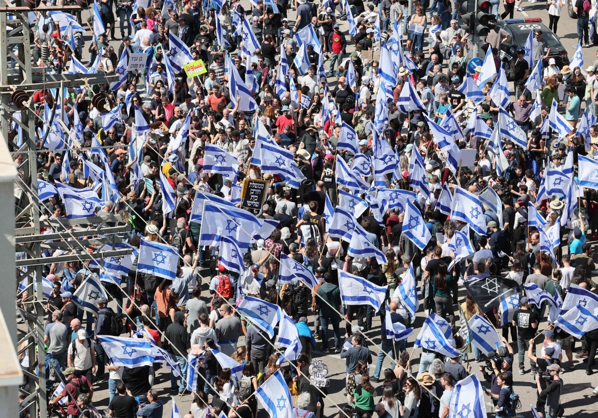 Israelíes ondean banderas nacionales mientras protestan contra el controvertido proyecto de reforma judicial del Gobierno en Tel Aviv