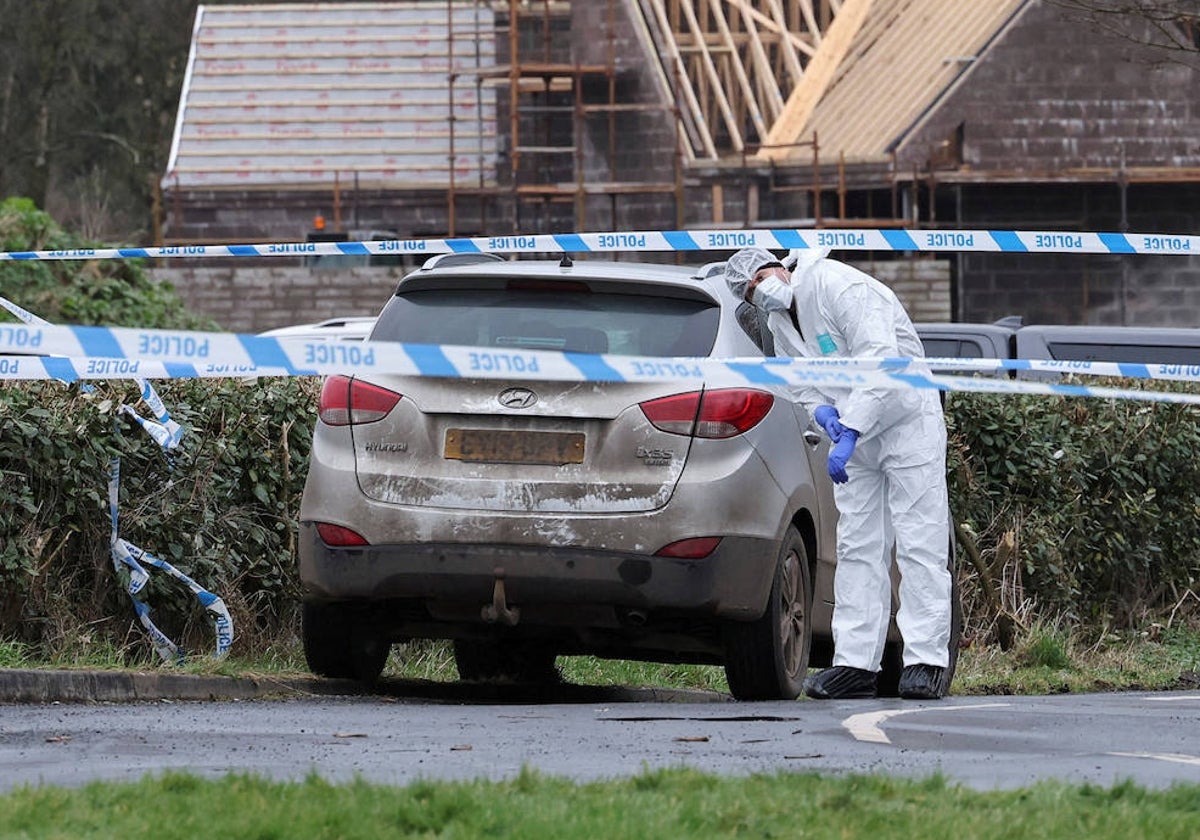 Un agente forense de la Policía de Irlanda del Norte, en el escenario donde fue tiroteado el inspector jefe John Caldwell