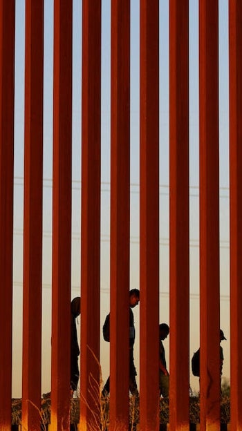 Un grupo de inmigrantes que intenta llegar a Estados Unidos camina junto al muro de Ciudad Juárez