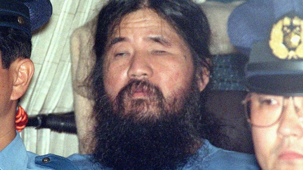 Shoko Asahara transportado por la policía después de ser condenado a muerte
