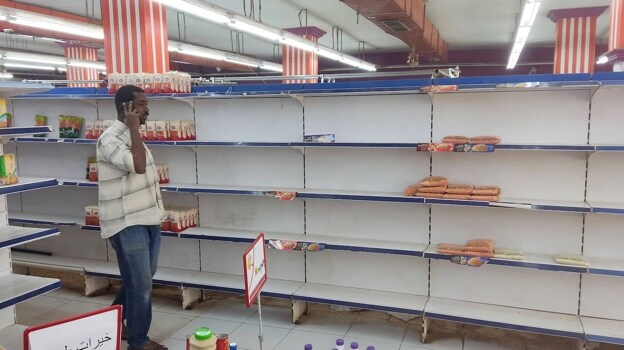 Food is scarce.  A man walks past empty shelves in a supermarket in Khartoum on May 18, 2023.