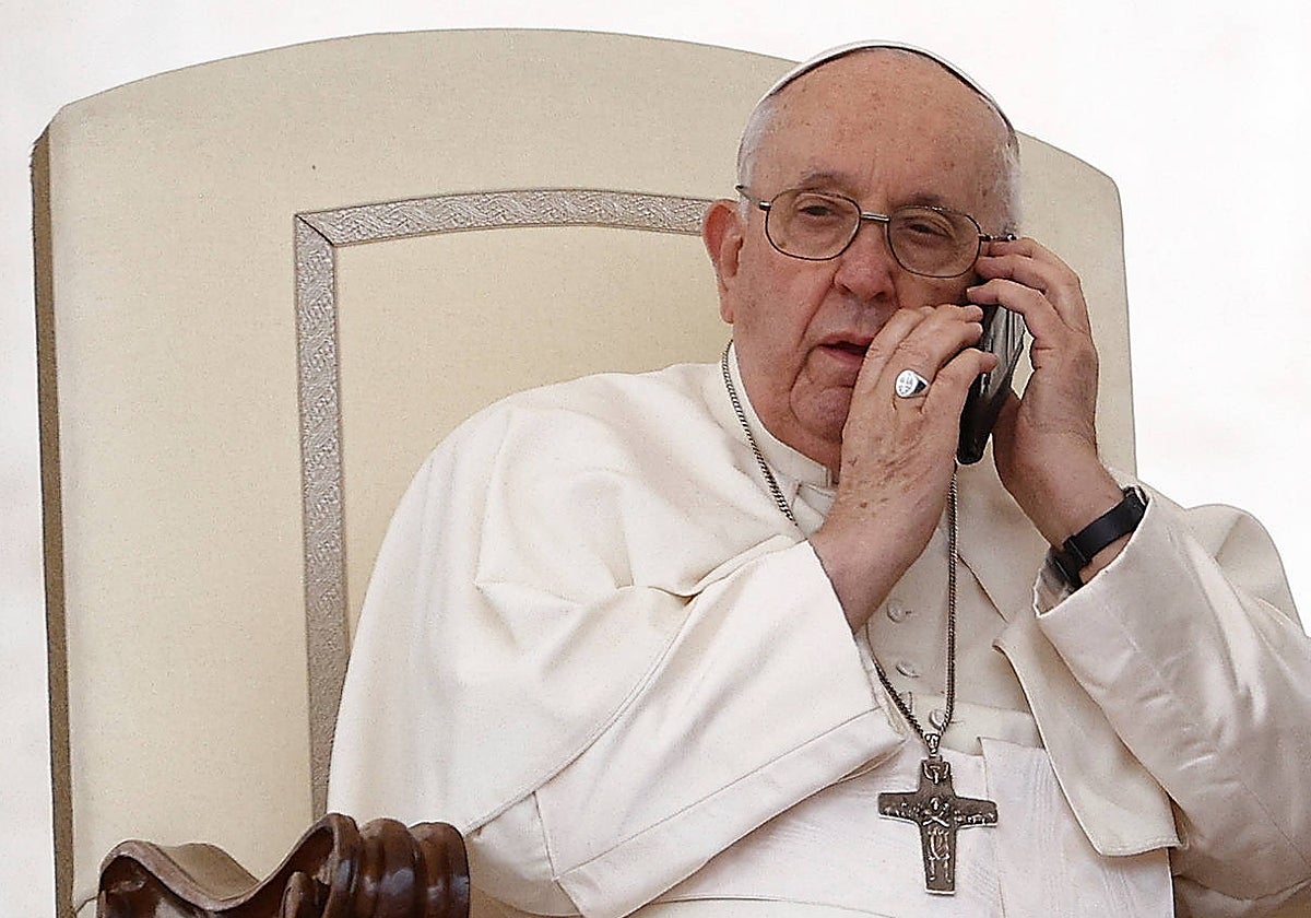 El Papa Francisco habla por teléfono durante la audiencia general semanal en la Plaza de San Pedro en el Vaticano