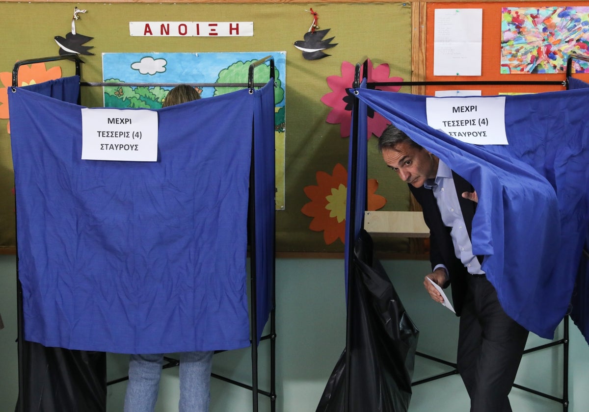 El primer ministro griego y líder del partido político Nueva Democracia, Kyriakos Mitsotakis, sale de una cabina electoral para depositar su voto en un colegio electoral en Atenas
