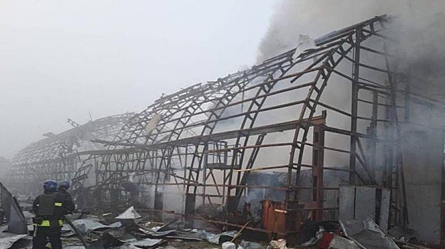 Un equipo de bomberos trabaja en una instalación de una empresa de transporte dañada por un ataque con misiles rusos, en medio de un ataque de Rusia en Dnipro