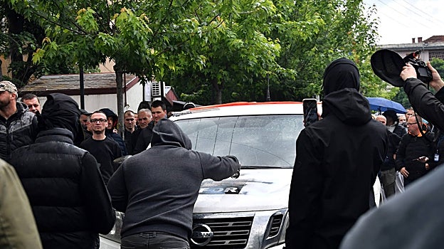 Un manifestante pinta con spray un vehículo de la KFOR frente al edificio del municipio en Zvecan, Kosovo