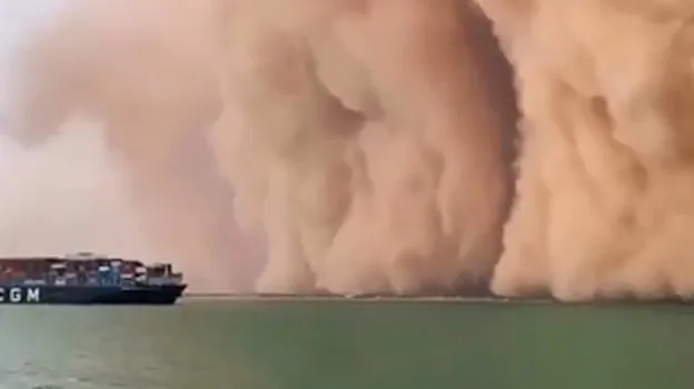 Momento en el que la tormenta de arena cubre un buque de carga
