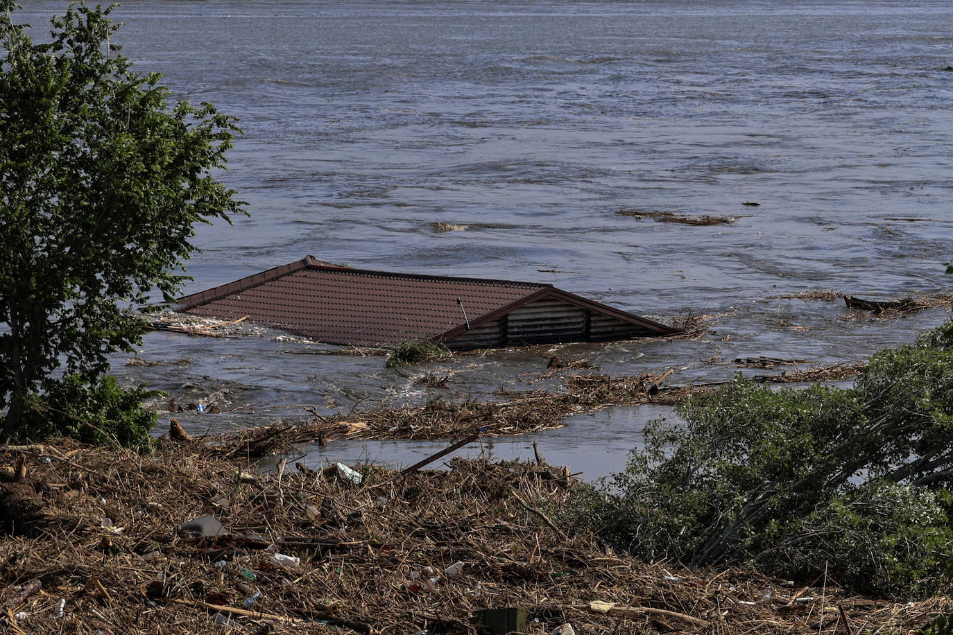 Fotografía en la que se ve el techo de una casa en el río Dnipro que se inundó después del ataque que destruyó la represa Nova Kakhovka, en Kherson