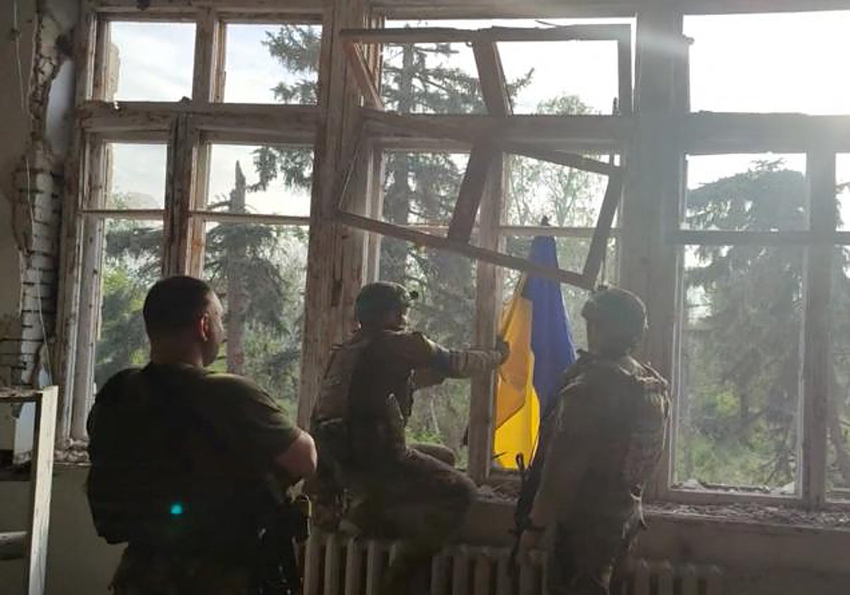 Soldados ucranianos izan la bandera del país en el primer poblado liberado en la contraofensiva