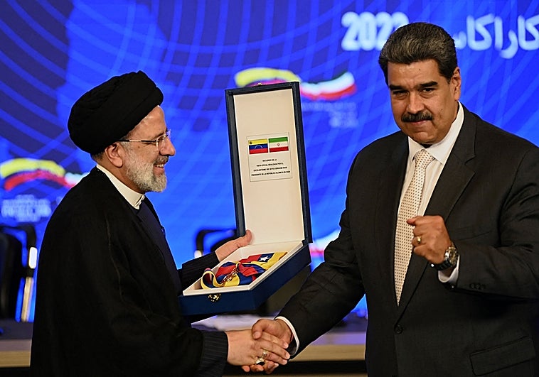 El presidente iraní, Ebrahim Raisi (i), recibe una condecoración conmemorativa de manos del presidente venezolano, Nicolás Maduro, tras una declaración conjunta a la presa en el Palacio Presidencial de Miraflores, en Caracas