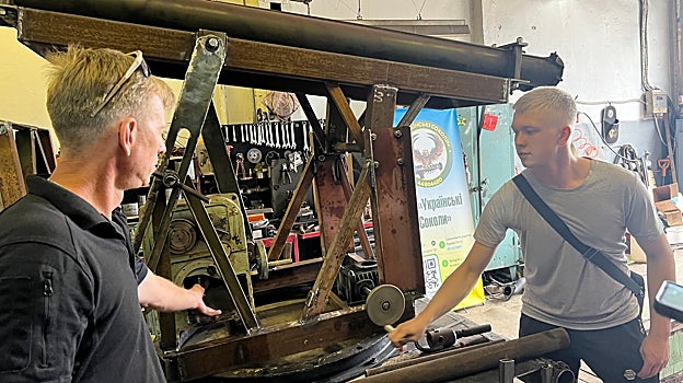 Yuri Sokolansk y Maksim, junto al mecanismo de una lanzadera de cohetes