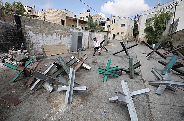 Un niño atraviesa una de las barricadas palestina utilizadas para evitar que las fuerzas de seguridad israelíes ingresen a Yenín
