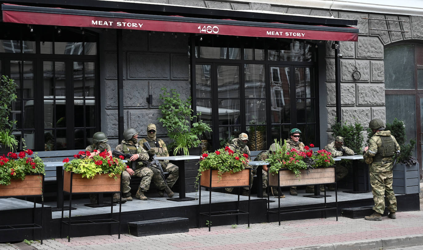 Los combatientes del grupo mercenario privado de Wagner descansan en un café mientras están desplegados en una calle cerca de la sede del Distrito Militar del Sur en la ciudad de Rostov