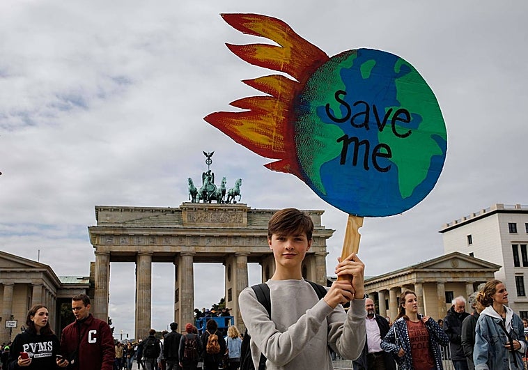 Frente activista climático en la Puerta de Brandeburgo.  En el cartel se puede leer 'Sálvame'