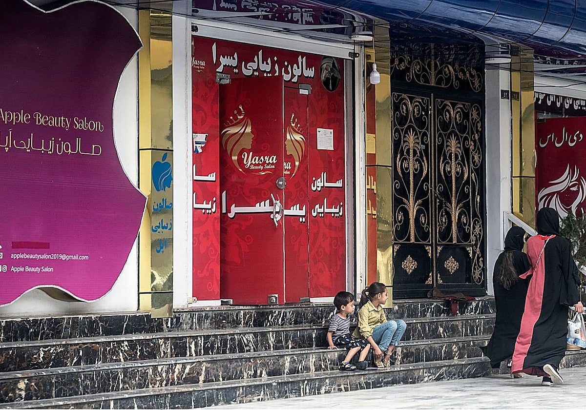 Las mujeres pasan frente a un salón de belleza en el área de Shahr-e Naw en Kabul el 4 de julio de 2023. Las autoridades talibanes de Afganistán ordenaron el cierre de los salones de belleza en todo el país dentro de un mes,