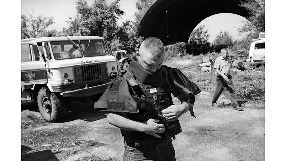 Ylia se pone el chaleco de protección antes de comenzar a trabajar en una antigua posición militar Rusa abandonada en el Este de Ucrania. Ylia forma parte de una unidad de desminado del servicio de emergencias de Ucrania.