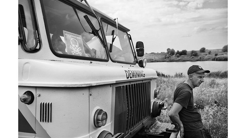 Artem descansa apoyado junto al camión blindado de la unidad de desminado de los servicios de emergencia de Ucrania. Artem es uno de los dos médicos de la unidad.