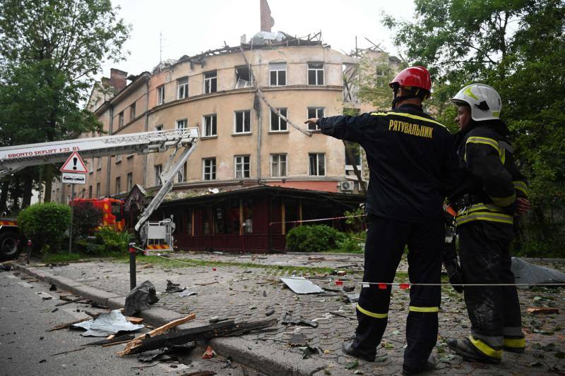 Trabajadores de los servicios de rescate frente a un edificio destruido en Leópolis.