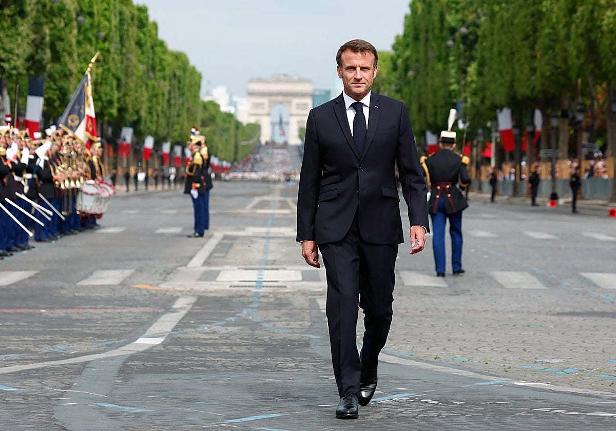Macron camina junto a los soldados vestidos de gala en los Campos Elíseos de París