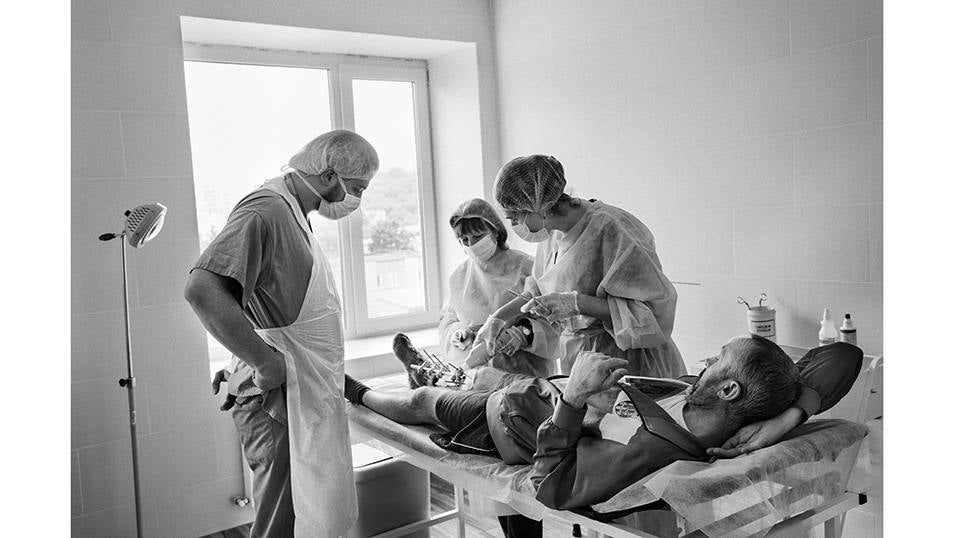 Leópolis, Ucrania - Junio 29, 2023: EL Doctor Danylo Turkevych que trabaja en el hospital San Panteleimon en Lviv visita a uno de sus pacientes durante la cura de la cirugía de un postoperatorio. El paciente del Doctor Danylo Turkevych se llama Vitaliy es de Bajmut. Justo después de evacuar a su mujer a inicios de marzo del 2023, cuando la artillería Rusa estaba atacando la ciudad, en un momento de pausa de los bombardeos, salió de su refugio cuando un mortero calló junto a él . Tuvo suerte porque junto a el también resultaron heridos dos soldados de la brigada 93 y fue evacuado con ellos. Ahora se recupera en de sus heridas en el hospital San Panteleimon en Leópolis