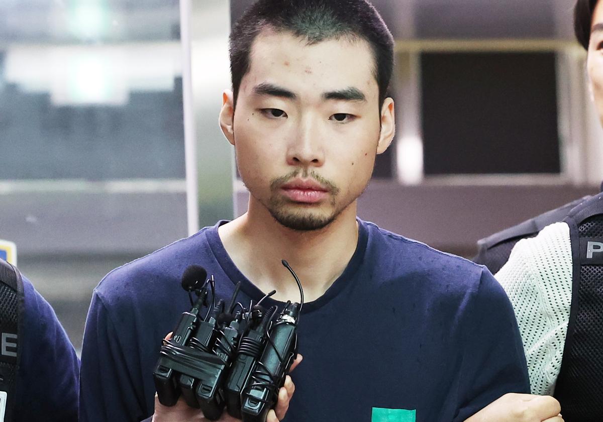 Choi Won-jong, un joven de 22 años detenido por un ataque con arma blanca, es escoltado a la salida de una comisaría de Seongnam, Corea del Sur