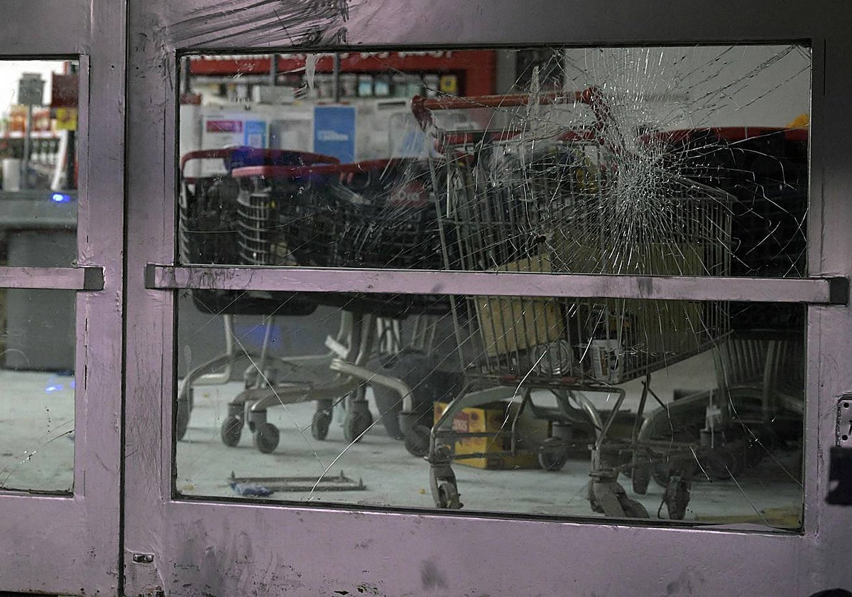 Imagen de los cristales rotos de la puerta de un supermercado «Día» tomada tras su saqueo en Argentina