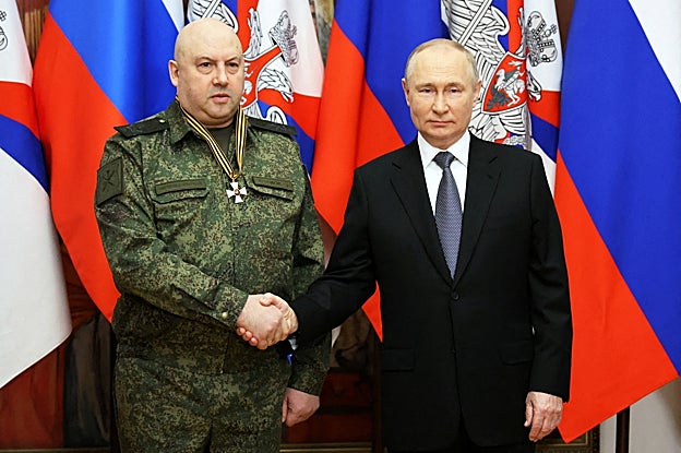 El general Serguéi Surovikin estrecha la mano del presidente Putin