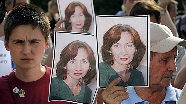 Personas sostienen fotos de la activista Natalia Estemirova, durante una concentración en protesta por su asesinato, en Moscú, Rusia