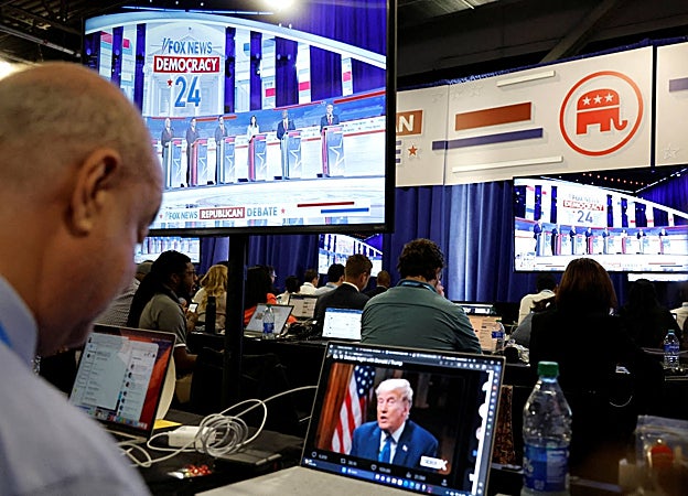 Un reportero observa la entrevista en línea del expresidente Donald Trump con Tucker Carlson durante el primer debate de candidatos republicanos de la campaña presidencial estadounidense de 2024 en Milwaukee, Wisconsin