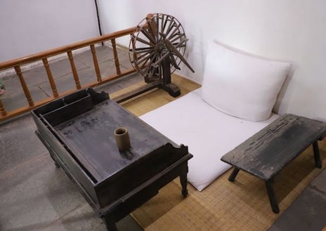 Imagen secundaria 1 - A orillas del río Sabarmati en la ciudad de Ahmedabad, en el estado occidental de Gujarat, se levanta esta casa de dos pabellones, pero muy humilde y sencilla, donde Gandhi se instaló en 1917, dos años después de volver de Sudáfrica (imagen superior) para dirigir el movimiento por la independencia de la India. Este 'ashram', mezcla de cooperativa y monasterio hinduista, todavía conserva la famosa rueca con la que Gandhi se pasaba horas hilando (arriba a la izquierda), símbolo de su dedicación y constancia. Como padre de la India, su figura es venerada por los más de 3.000 turistas que cada día visitan el lugar (arriba a la derecha).