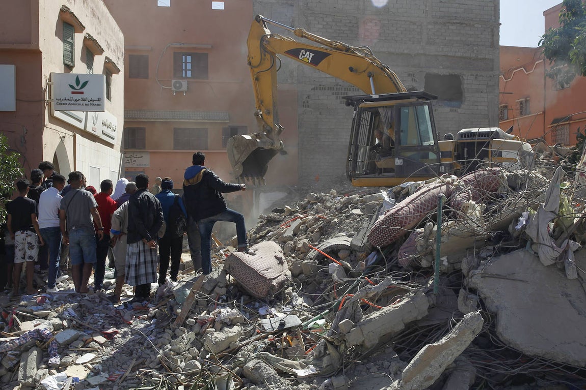 Una máquina excavadora ayuda en las tareas de búsqueda de supervivientes entre los escombros de edificios derruidos en la población de Amizmiz
