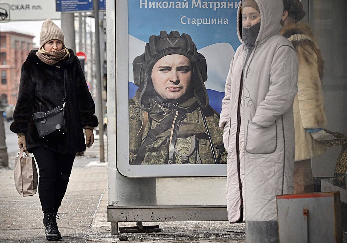 Cartel de un soldado ruso que combate en Ucrania en un poste de Moscú