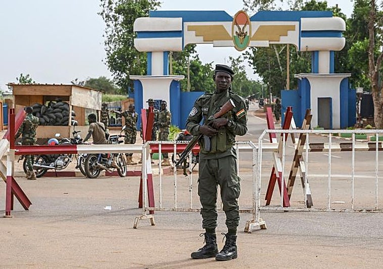 Un oficial de la Policía Nacional de Níger hace guardia mientras los partidarios del Consejo Nacional de Salvaguardia de la Patria (CNSP) de Níger protestan frente a la base aérea de Níger y Francia en Niamey