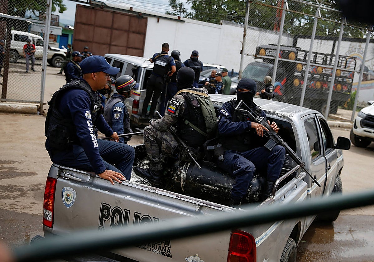 Miembros de la Policía Nacional Bolivariana esperan en un convoy en el puesto de control de la cárcel de Tocorón