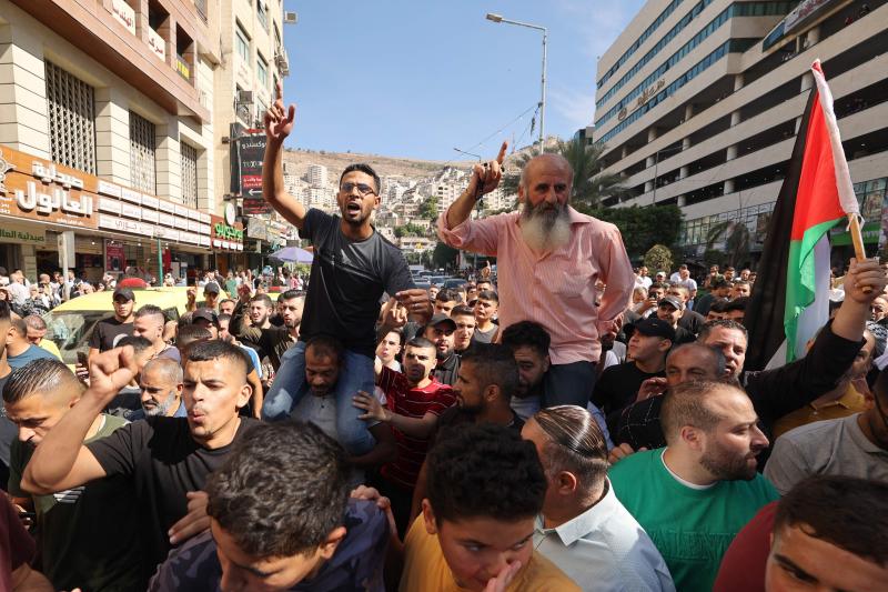 Palestinos en la ciudad cisjordana de Naplusa celebran que combatientes de la Franja de Gaza se hayan infiltrado en Israel.