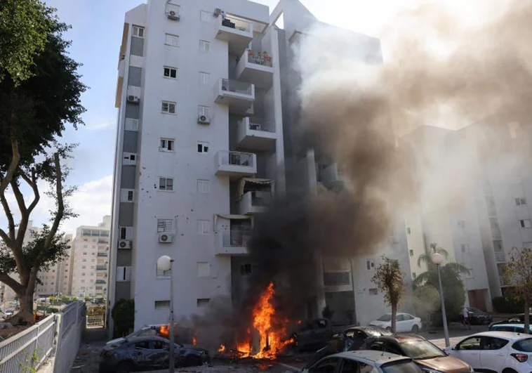 Coches aparcados frente a un edificio residencial se incendian durante un ataque con cohetes desde la Franja de Gaza contra la ciudad de Ashkelon, en el sur de Israel