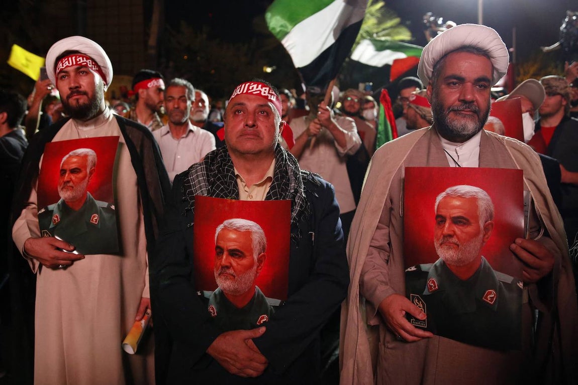 Un grupo de iraníes sostiene fotografías del comandante de la Guardia Revolucionaria Qasem Soleimani mientras asisten a una celebración de los atentados de Hamás en Teherán el 7 de octubre de 2023.