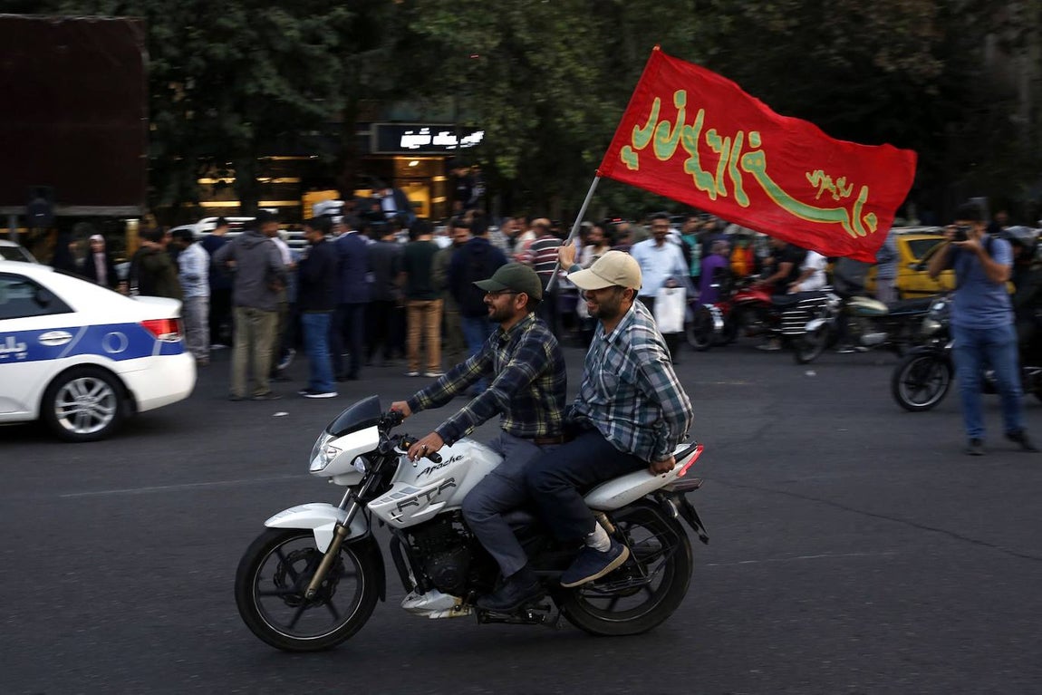 Dos iraníes suben en moto y alzan una bandera en Teherán para celebrar los atentados de Hamás contra Israel. Irán es uno de los pocos países que ha expresado su respaldo a los palestinos radicales que han perpetrado las matanzas.