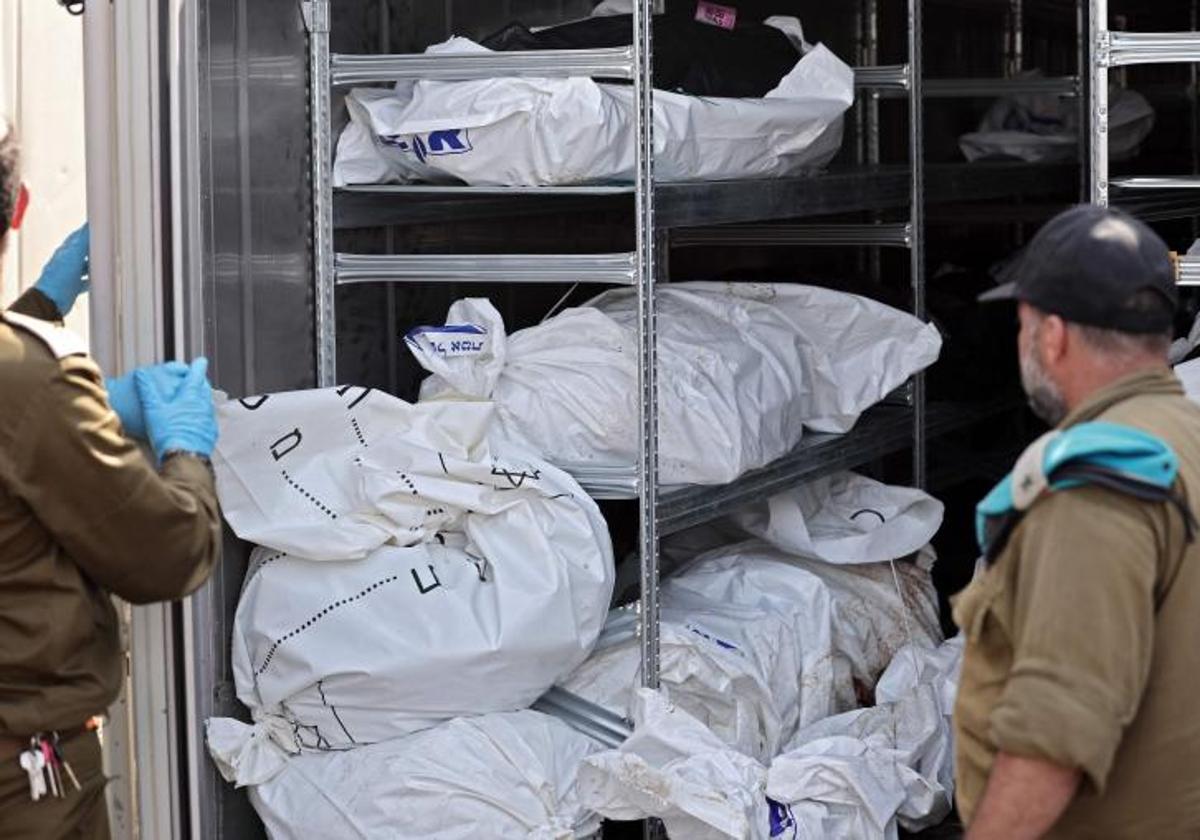 Forenses y soldados israelíes junto a un contenedor donde se almacenan los cadáveres en la base militar de Ramla