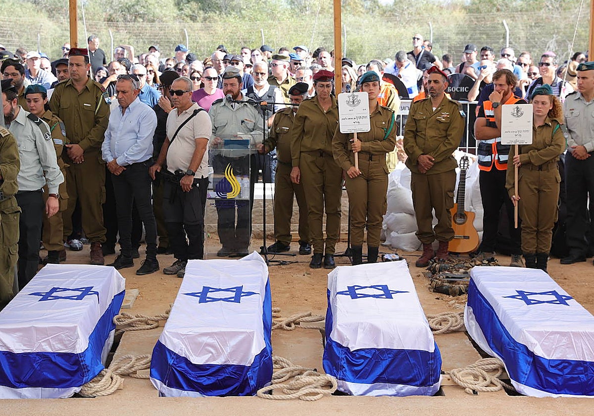 Varios militares israelíes participan en el funeral de una familia asesinada por los terroristas de Hamás en el kibutz de Kfar Aza