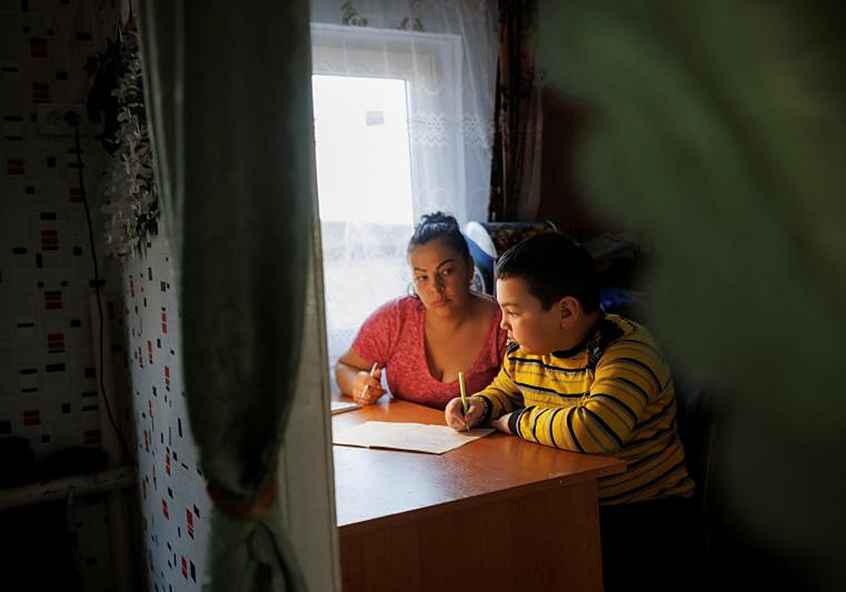 Una madre ucraniana ayuda a su hijo con los deberes escolares