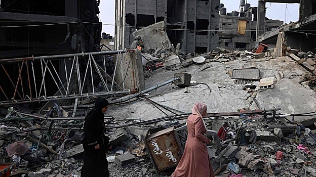 Mujeres pasan junto a un edificio destruido tras el bombardeo israelí en Rafah, en el sur de la Franja de Gaza