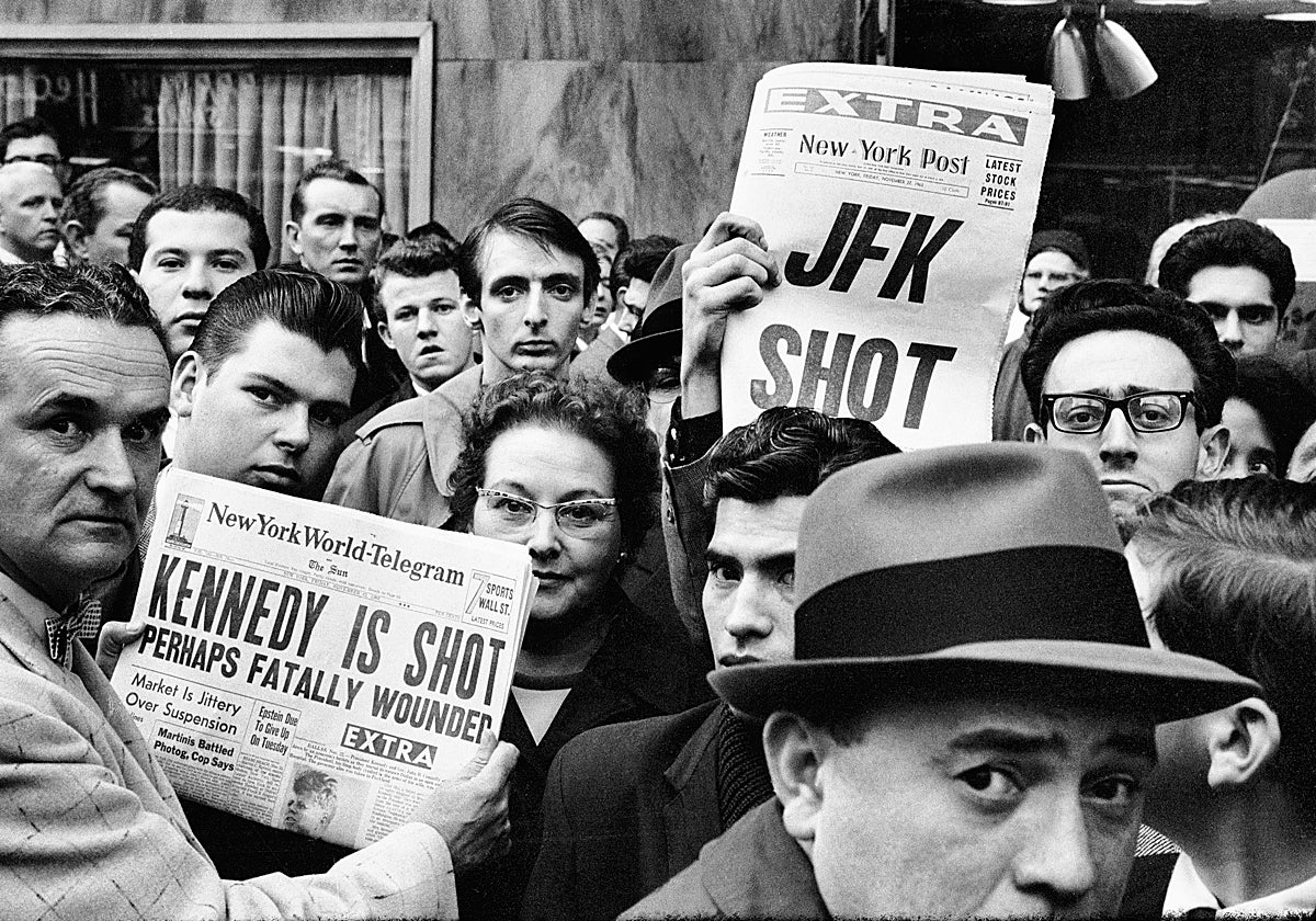 Varios neoyorquinos leen la prensa en Times Square un día después del atentado contra John Fitzgerald Kennedy