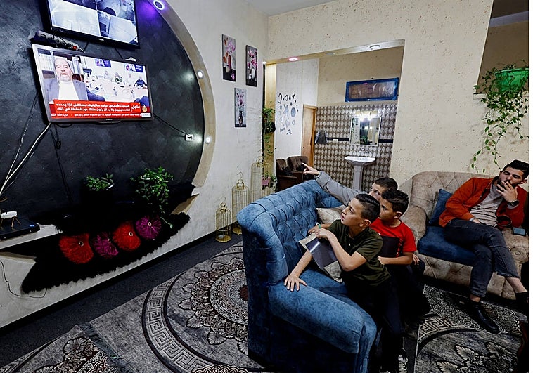 La familia de un joven prisionero palestino mira por televisión las noticias sobre el acuerdo de intercambio de rehenes israelíes y prisioneros palestinos , cerca de Hebrón