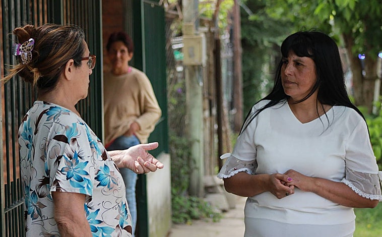 Imagen principal - Arriba, María Rosa Díaz charla con una vecina. Abajo, calles del barrio