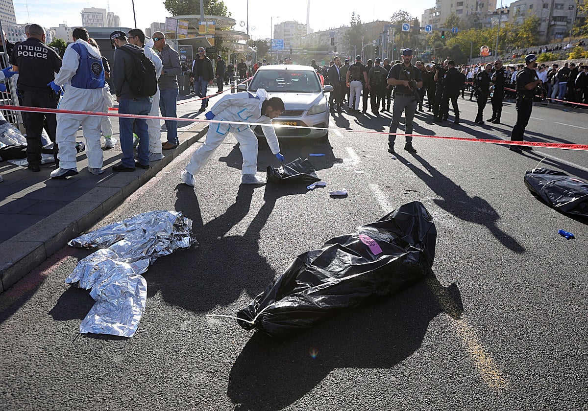 La policía cubre los cuerpos de una mujer de 24 años, un hombre de 73 y una mujer de unos 60 años que han muerto este jueves en un ataque palestino con disparos en uno de los accesos a Jerusalén, donde otras seis personas resultaron heridas, tres de ellas aún en estado crítico, confirmó la Policía