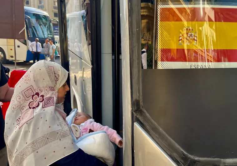 Con su bebé, una hispanopalestina evacuada de Gaza sube al autobús en El Cairo para ser repatriada ea España